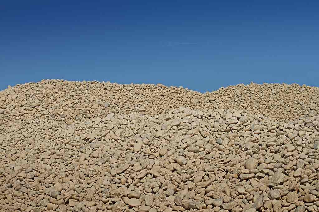 Fotografía de un montón de rocas de diferentes tamaños y formas apiladas en una armonía natural bajo un cielo azul claro.