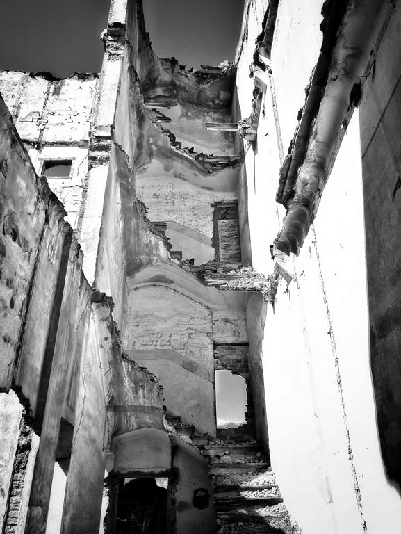 Fotografía en blanco y negro muestra el interior de una casa abandonada