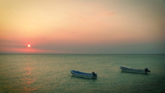 Botes en el mar durante la puesta sol
